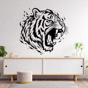 May include: Black and white illustration of a roaring tiger head with a detailed design. The tiger's mouth is open, showing its teeth and tongue. The illustration is set against a white background.