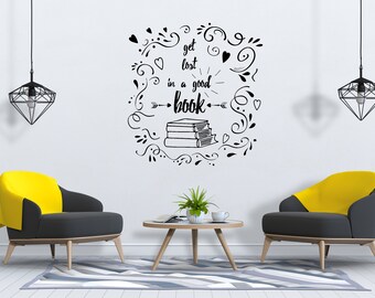 Puede incluir: Un interior de sala de estar con dos sillones amarillo y gris, una mesa de café y una lámpara colgante negra. La pared tiene una cita en blanco y negro que dice "get lost in a good book" con una pila de libros y elementos decorativos.