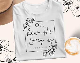 May include: White t-shirt with a black graphic that says "Oh, how He loves us" and "1 John 4:10". The graphic is surrounded by floral designs.