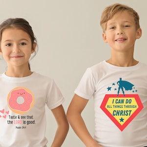 Puede incluir: Dos ni&ntilde;os con camisetas blancas con dise&ntilde;os diferentes. La camiseta de la ni&ntilde;a tiene un donut rosa con una cara sonriente y el texto "Taste & see that the LORD is good. Psalm 34:8". La camiseta del ni&ntilde;o tiene un superh&eacute;roe con una capa roja y amarilla y el texto "I CAN DO ALL THINGS THROUGH CHRIST".