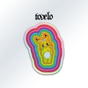 May include: A sticker featuring a cartoon lynx with a pink bow, holding a blue and white heart, surrounded by rainbow-colored concentric circles. The text "toxelo" is above the image.