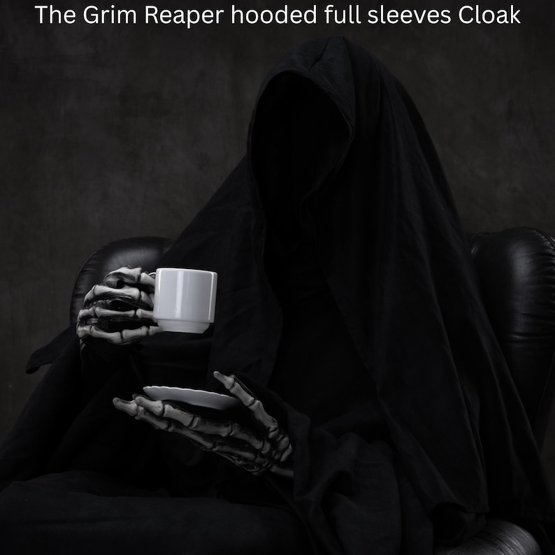 May include: A black hooded cloak with full sleeves worn by a figure with skeletal hands holding a white ceramic coffee cup and saucer. The text at the top of the image reads: The Grim Reaper hooded full sleeves Cloak. The garment is solid black.