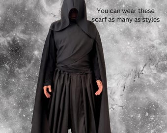 May include: A black hooded cloak and matching loose-fitting trousers. The garment features a draped wrap-style bodice and a deep hood. The text "You can wear these scarf as many as styles" is visible on the right side of the black hooded outfit.