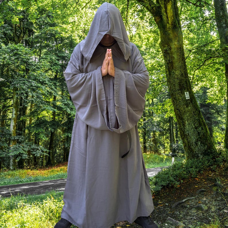 May include: A full-length, solid grey robe featuring long, wide sleeves and an attached hood that covers the head. The garment is constructed from a smooth, opaque fabric and hangs loosely from the shoulders to the floor, creating a draped silhouette.