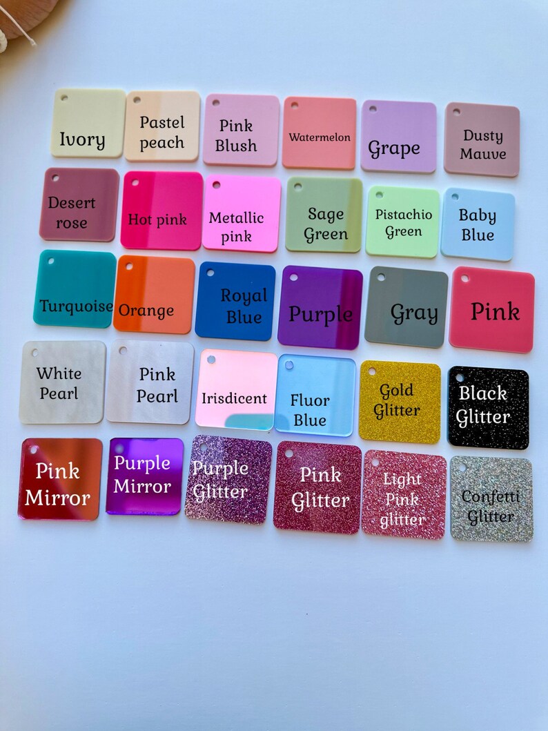 May include: A selection of square acrylic colour swatches in various shades, including ivory, pink, blue, green, and purple. Each swatch has a small hole and a printed colour name, such as "Gold Glitter" and "Baby Blue."