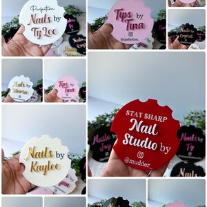 May include: A selection of car coasters in different colours, each displaying a nail salon's name. Coasters include names such as "Ty Lee," "Tina," "Kaylee," and "Mic." The coasters are round with a distinctive notched design.