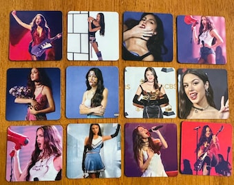 May include: A collage of 12 square images featuring a young woman in various poses and settings. The images include the woman playing guitar, holding a microphone, wearing a cheerleading uniform, and holding an award. The images are arranged in a grid pattern on a wooden surface.