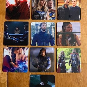 Puede incluir: Un conjunto de posavasos cuadrados con varios personajes del Universo Cinematográfico de Marvel. Los posavasos muestran imágenes de Doctor Strange, Thor, Capitán América y otros, con colores vibrantes y retratos detallados.