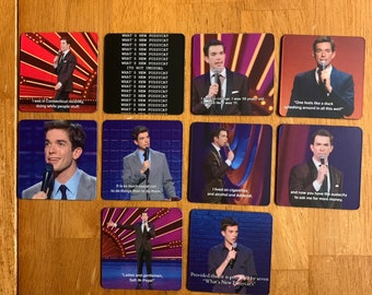 May include: A collection of square coasters featuring images of a comedian on stage. Each coaster has a different image and quote from the comedian's stand-up routine. The coasters are on a wooden surface.