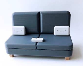 The Charcoal Colab Couch Phone Holder with Remote and Pillows