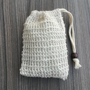 Puede incluir: Una bolsa de cord&oacute;n de malla blanca con una cuenta de madera en el cord&oacute;n. La bolsa est&aacute; hecha de un material fino y tejido y est&aacute; dise&ntilde;ada para contener jab&oacute;n u otros art&iacute;culos peque&ntilde;os.