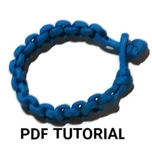 Peut inclure: Un bracelet en paracorde bleu vif avec un nœud à l'extrémité. PDF TUTORIAL est écrit sous le bracelet.