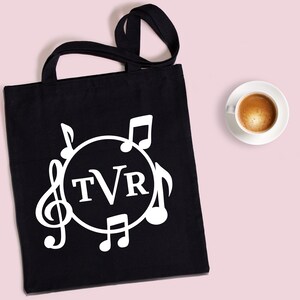 May include: Black tote bag with white musical notes and a circle containing the letters "TVR".