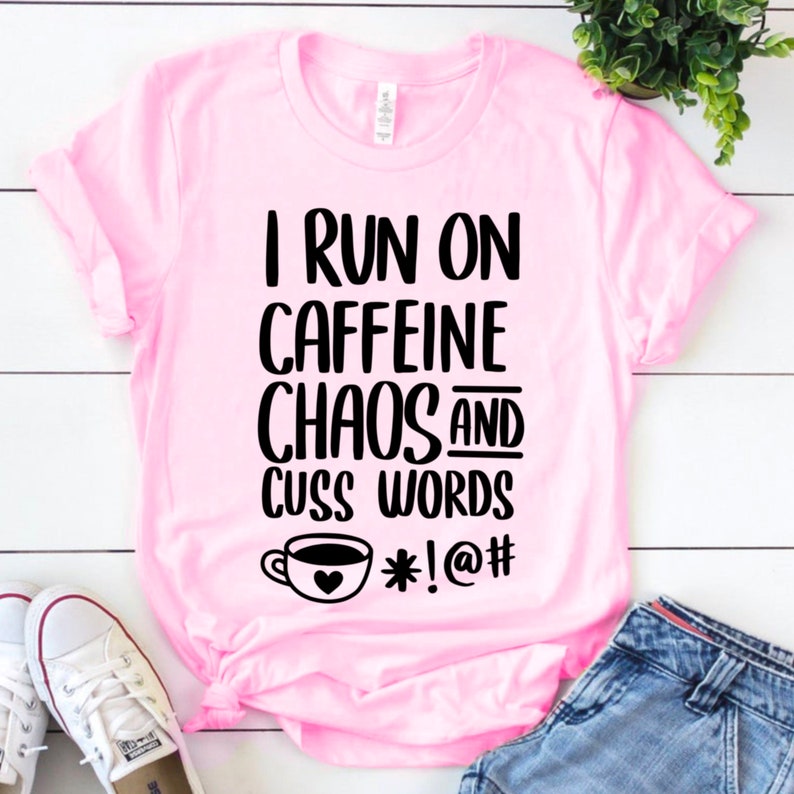 May include: Pink t-shirt with black text that reads "I run on caffeine chaos and cuss words *!@#" with a coffee cup graphic.