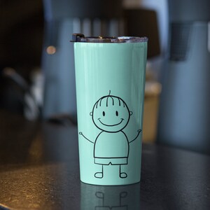 Op de afbeelding: Een lichtgroene roestvrijstalen beker met een zwart-witte illustratie van een lachend stick figure met uitgestrekte armen.