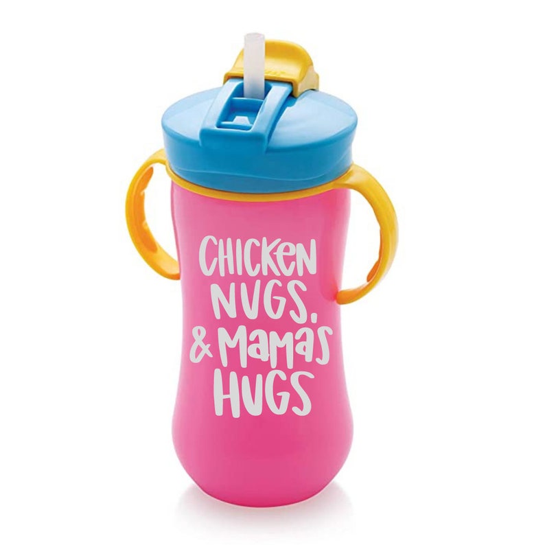 May include: Pink plastic sippy cup with two handles and a yellow lid. The cup has a straw and says "Chicken Nugs & Mama's Hugs" in white lettering.