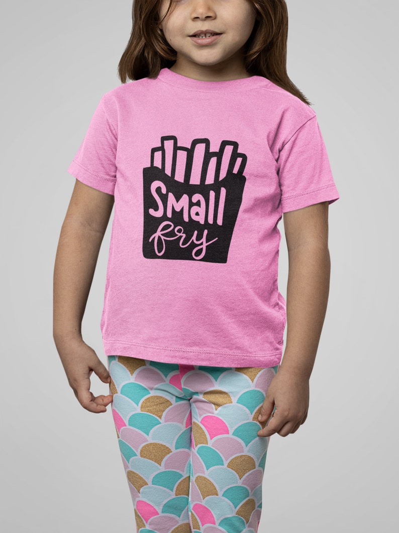 May include: A pink t-shirt with a black graphic of french fries and the text "Small fry".