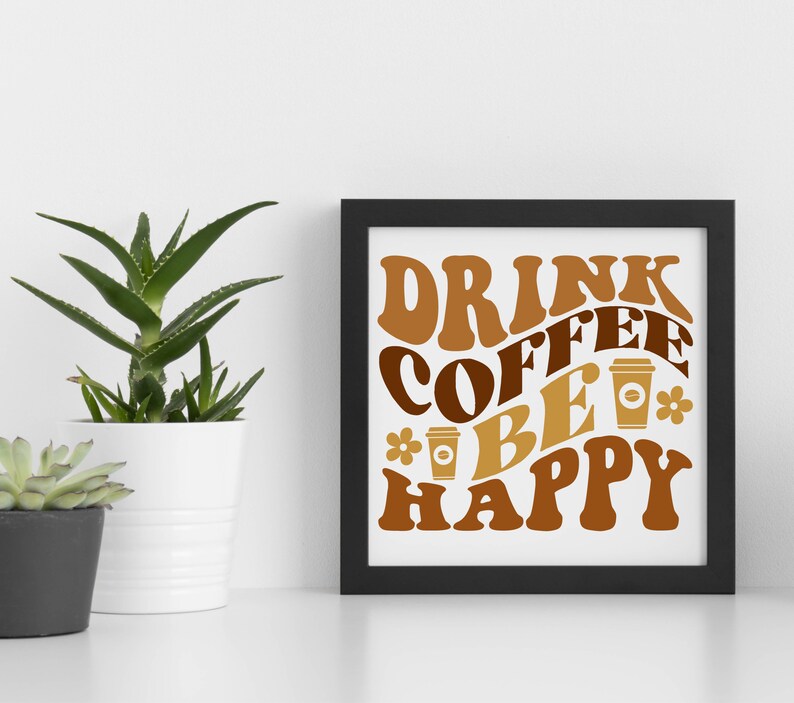 May include: A black framed print with the text "Drink Coffee Be Happy" in brown and gold lettering with stylized coffee cups and flowers.
