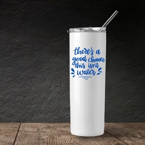 May include: White stainless steel tumbler with a blue inscription that reads "there's a good chance this isn't water".