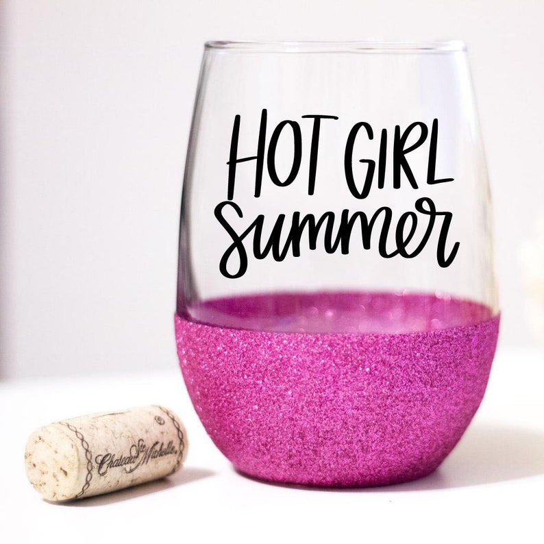 May include: A pink glitter wine glass with the text "HOT GIRL Summer" in black lettering.