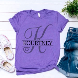 May include: Purple t-shirt with a split monogram design. The letter "K" is in a script font and the name "Kourtney" is printed below the letter.