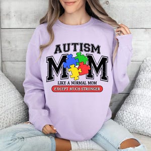 May include: Purple sweatshirt with the text "Autism Mom Like a Normal Mom Except Much Stronger" and a puzzle piece design.