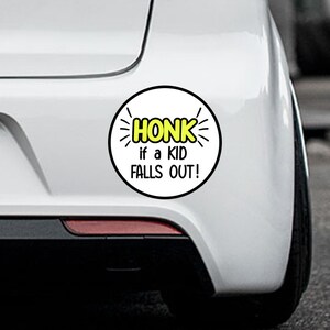 May include: White car bumper sticker with black outline and yellow text that reads "HONK if a KID FALLS OUT!"
