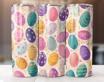Puede incluir: Tres vasos aislados de acero inoxidable con un patrón repetido de coloridos huevos de Pascua. Los huevos están decorados con varios patrones y colores, incluyendo rosa, azul, morado y amarillo, sobre un fondo beige con pequeños corazones.