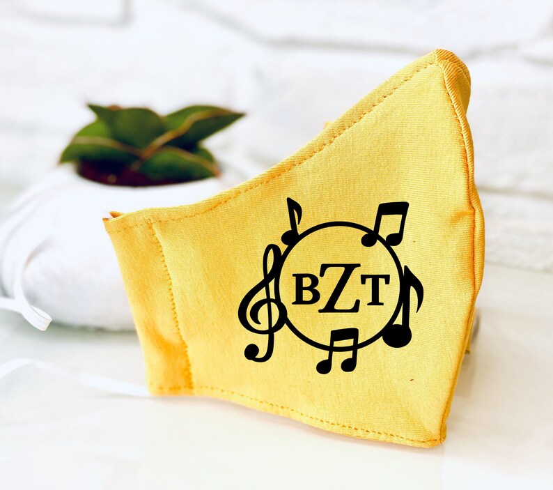 May include: Yellow fabric face mask with a black musical note design and the initials "BZT" in a circle.