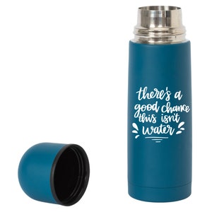 May include: A teal blue stainless steel thermos with a white inscription that reads "there's a good chance this isn't water". The thermos has a matching teal blue lid.