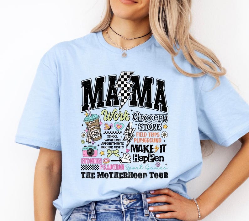 May include: Light blue t-shirt with a graphic print that says "MAMA Work Grocery Store Field Trips Playground Make It Happen Kitchen Practice Sport Games The Motherhood Tour".