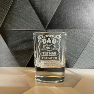 May include: A clear glass shot glass with an etched design that says "Dad Best No. 1 The Man The Myth".