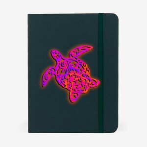 K&ouml;nnte beinhalten: Ein dunkelgr&uuml;nes Notizbuch mit einem pinkfarbenen und orangefarbenen Muster einer Meeresschildkr&ouml;te auf dem Einband.
