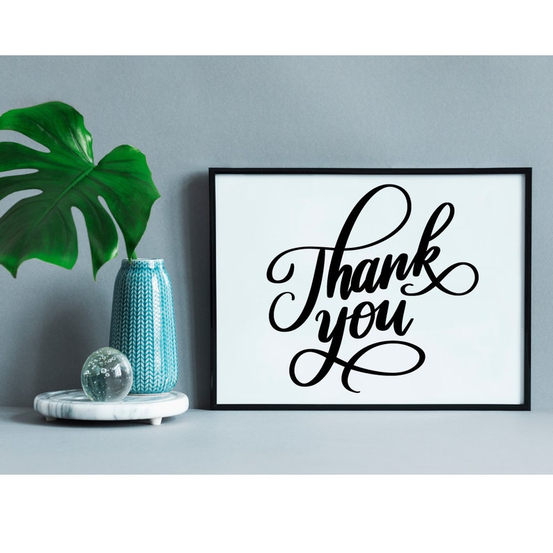 May include: A black framed print with white background featuring the text "Thank you" in a decorative script font.