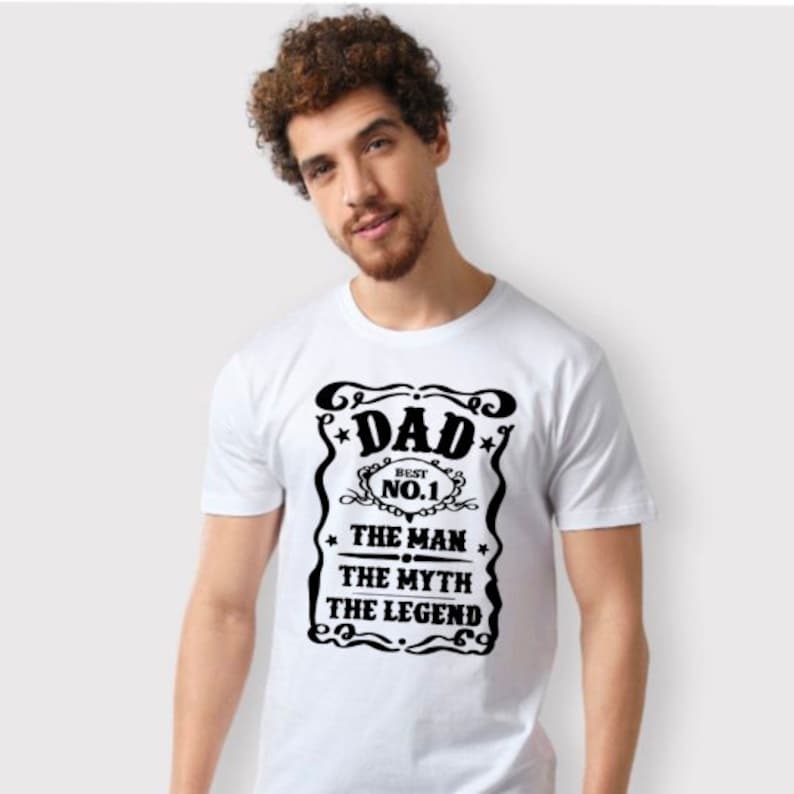 May include: White t-shirt with a black graphic design that says "Dad, Best No.1 The Man The Myth The Legend".