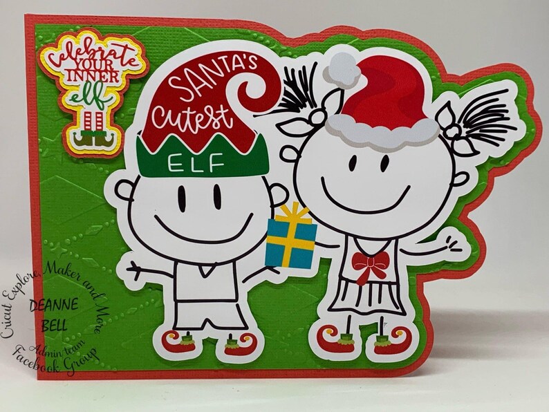 May include: A handmade Christmas card featuring two stick-figure elves. One elf is holding a gift. The card has the text "Santa's Cutest Elf" and "Celebrate Your Inner Elf". The card is green and red.