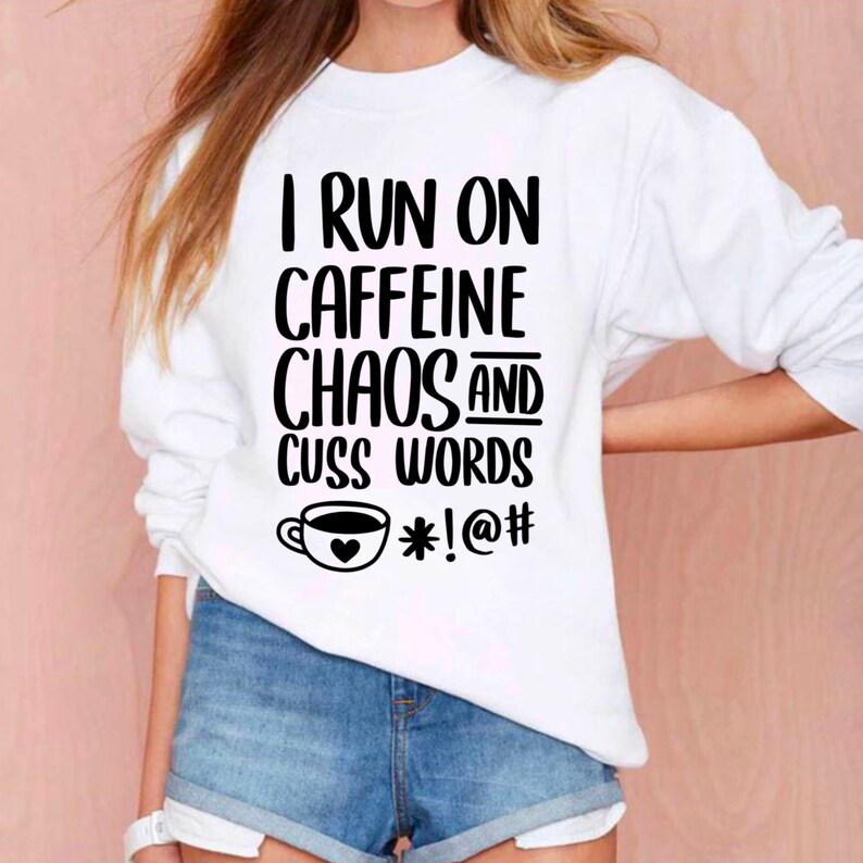 May include: White sweatshirt with black text that reads "I run on caffeine chaos and cuss words *!@#" with a coffee cup graphic.