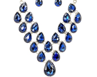 Blue crystal statement necklace and earring set created with blue sapphire color crystals in all teardrop shapes in silver plated settings.