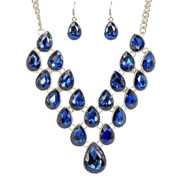 Blue crystal statement necklace and earring set created with blue sapphire color crystals in all teardrop shapes in silver plated settings.