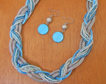 Turquoise color twisted wrapped necklace and earring set created with turquoise seed beads, silver seed beads, and silver mesh chain.