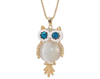 White owl pendant necklace with a round white cat eye stone center, blue crystal eyes, clear crystals on top, and the feathers swing