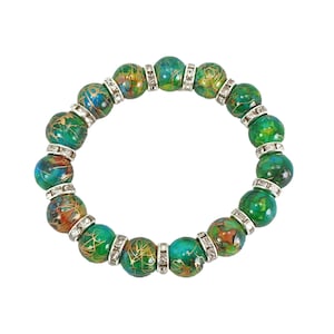 Bracelet extensible en perles de verre vert avec des perles intercalaires en cristal. Créé avec des perles de verre peintes à la main dans plusieurs couleurs mélangées avec du vert