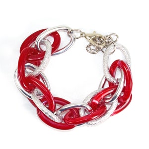 Red and silver link bracelet designed with shiny red acrylic links and silver plated links with a textured and shiny finish.  7.5 inches