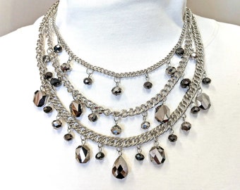 Multi row necklace designed with facet cut black diamond gray glass beads in various shapes.  Layered necklace with gray glass beads.