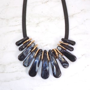 Black bead statement necklace with long black acrylic beads that have a white color in them to give it a marble look.