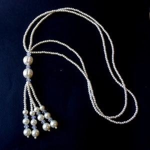 Long double strand white pearl tassel necklace with two large round beads and glass beads on the tassel.  Fashion pearl tassel necklace.