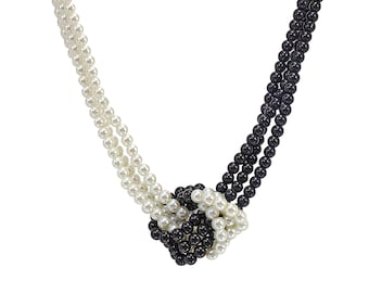 Black and white beaded multi strand necklace with knot in front and made with 6mm acrylic beads. Black and white statement necklace.