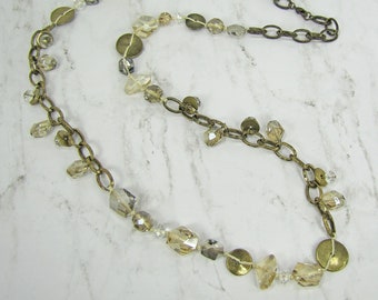 Long brown glass bead & metal disks necklace created with a combination of metal textured links all hand knotted in a burnished gold finish.