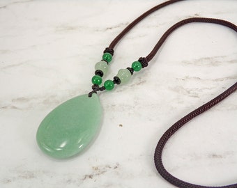 Large green aventurine stone pendant necklace in a teardrop shape attached to a brown cord necklace.  Natural green stone pendant.