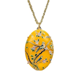 Large yellow oval pendant with a beautiful nature scene applied to the top in enamel, with birds, pink flowers, and brown tree branches